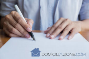 Foto di persona che firma un contratto per una domiciliazione abusiva
